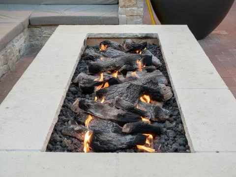 Long, rectangular fire pit sitting in open air plaza Stock Photos