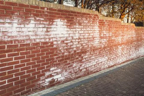 A long red brick wall stained with white efflorescence, a crystalline of salt Stock Photos