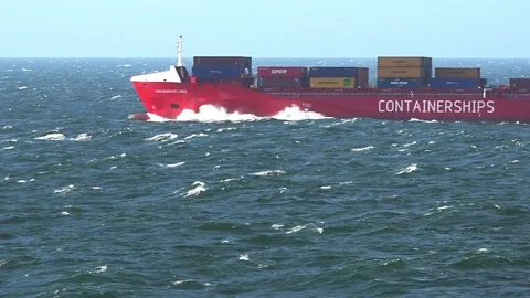 Long red cargo ship sails on deep blue endless sea water Stock Footage 114262801