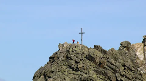 Long reverse zoom from helicopter showing hikers on a mountain peak Stock Footage 22959896