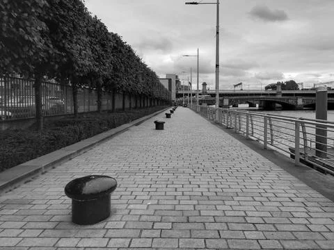 A long riverside walkway paved with stone Stock Photos