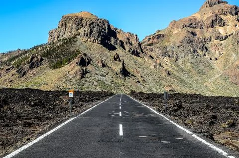 A long road with a mountain in the background Stock Photos