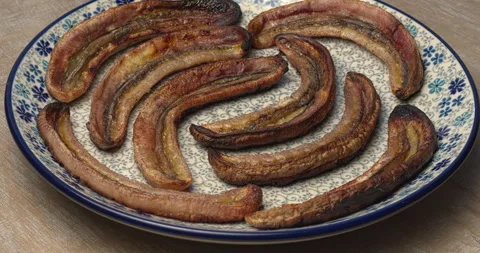 Long roasted bananas on a plate. Stock Footage 308254878