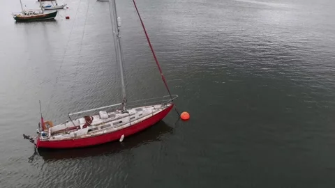 A long round drone shot of the red boat in the Conwy bay Stock-Footage 146187716