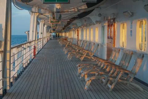 A long row of empty deck chairs on the Promenade Deck of a cruise ship Stock Photos