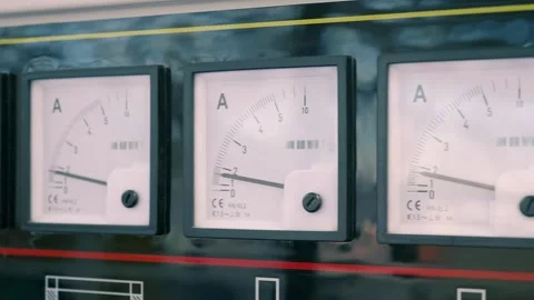 A long row of square pointer ammeters on a black, glossy industrial equipment Video stock 333348371