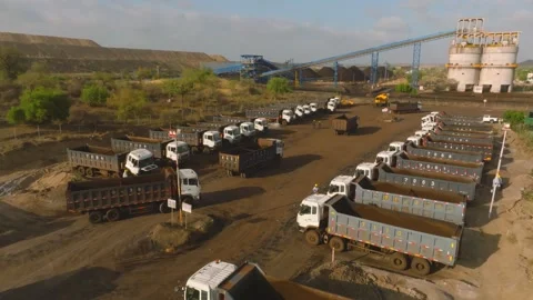 Long rows of loaded coal dump trucks queue in the Thar Engro Coal Mining yard Stock Footage 344055737