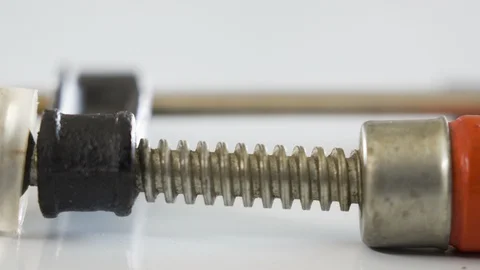 The long screw of the clamp tool with the red capsule Stock Footage 129458020