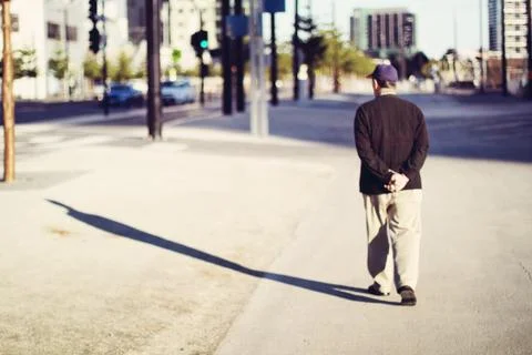 Long shadow cast of a man walking in sidewalk 库存照片