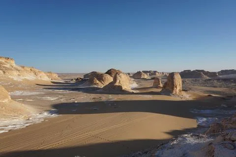Long shadows of rock formations in the white desert Stock Photos