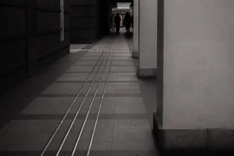 Long shadowy corridor with distant people 스톡 사진