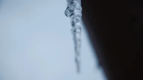 Long sharp icicle hanging on roof Stock Footage 100541483