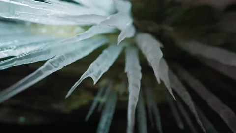 Long sharp icicles hang in cave. Ice spikes illuminated with white led light Stock Footage 166566689