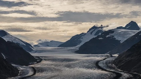 Long shot of clouds flowing over valley with receding glacier and lush green Stock Footage 114009508