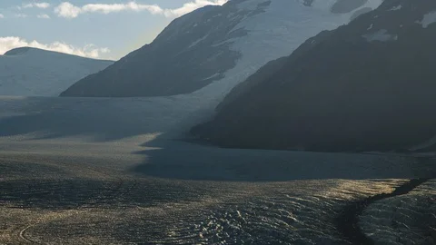 Long shot of clouds flowing over valley with receding glacier and lush green Stock Footage 114010208