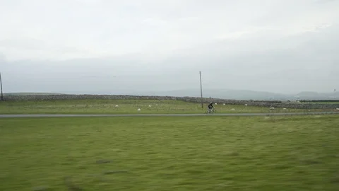 Long Shot of Cyclist Riding Through British Countryside 4K Stock Footage 89998259