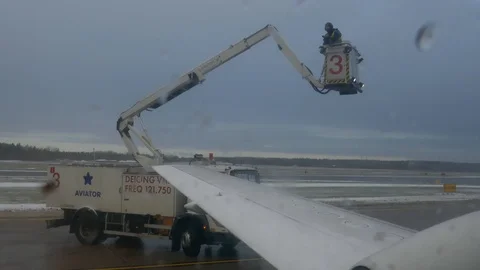 Long shot of de icing the airplane during winter to prepare for flight departure Stock Footage 88880495