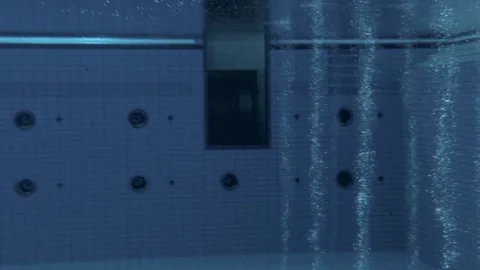 Long Shot of diver submerging in deep olympic swimming pool Stock Footage 135086291