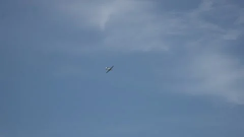 Long shot of flying away small-seat plane in patrially cloudy sky when summer 動画素材 220494136