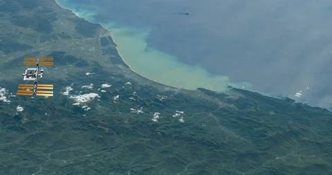 Long shot: flying parallel to the ISS, over the Italian coastline Video stock 120148941