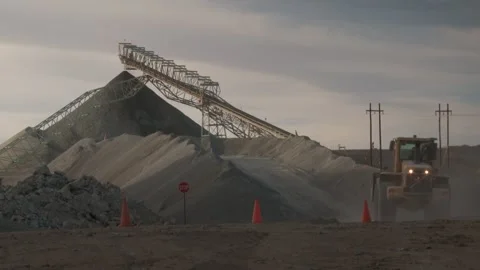 Long shot of a loader driving up a mound and depositing its load Stock Footage 312400507