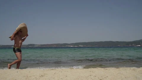 Long shot of a man having fun at the beach. Man in sunglasses with big summer Stock Footage 147949252