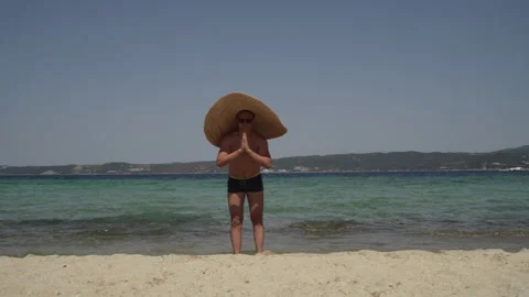 Long shot of a man having fun at the beach. Man in sunglasses with big summer Stock Footage 147949362