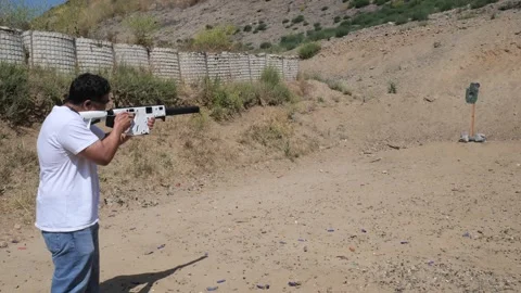 Long shot man shooting vector rifle at steel reactive target Stock Footage 276921580