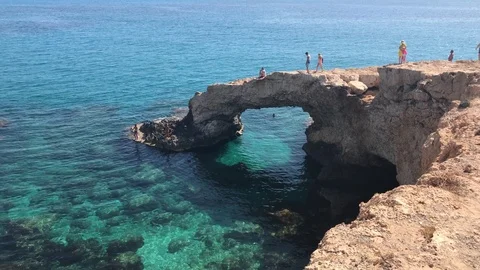 Long Shot of People over a cliff arch in Ayia Napa Stock Footage 91056852