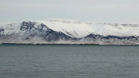 Long shot right to left pan of Reykjavik snowy Esja mountain Stock Footage 93219216
