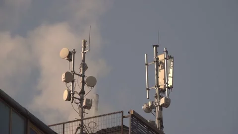 Long shot of rooftop of building. Dish antennas for satellite tv cloudy sky. Stock Footage 229932981