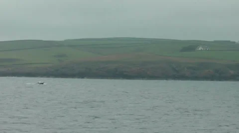 Long shot small blue and white motorboat sailing along coast of Scotland Stock Footage 36840130