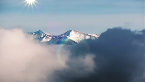 Long shot of snow-capped mountain peaks, shrouded in clouds Stock Footage 230719372