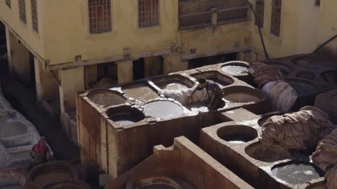Long shot of tannery leather workers dyeing white leather in Fes Stock Footage 265488009