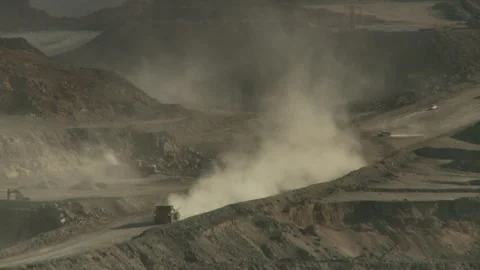 Long shot of three construction vehicles driving through opencast mine Stock Footage 312400351