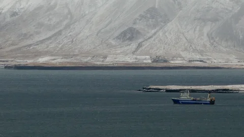 Long shot view of a ship sailing in sea water with snowy mountain in background Stock Footage 93219957