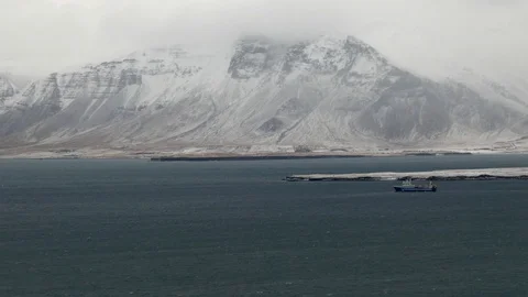 Long shot view of a ship sailing in sea water with snowy mountain in background Stock Footage 93219966
