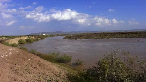 In a long shot a wide river flows serenely through, stock footage. Stock Footage 304784577