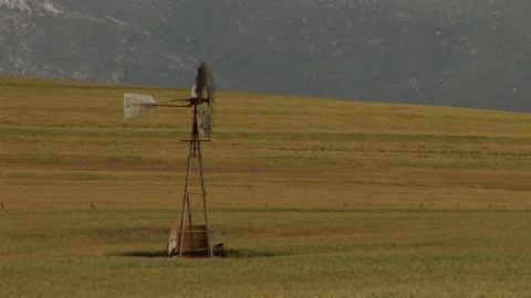 Long shot of a windmill in a field Stock Footage 310388648