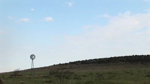 Long-shot of a windmill standing in a pasture in Texas Stock Footage
