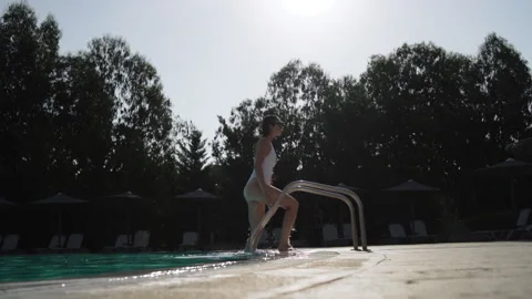 Long side shot of the young lady in the white wet swimsuit and sunglasses Stock Footage 147845638