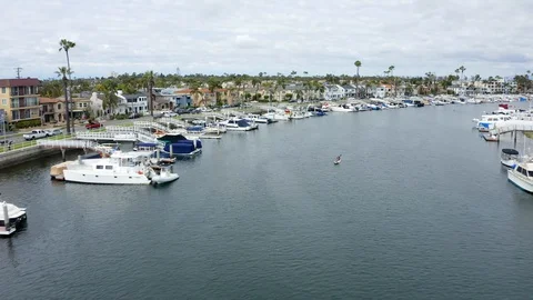 Long single drone shot flying down Naples boat canals in Long Beach, CA Stock Footage 128977624
