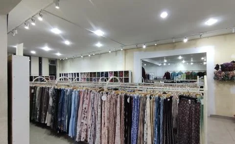 Long skirts displayed on racks inside a clothing store Stock Photos