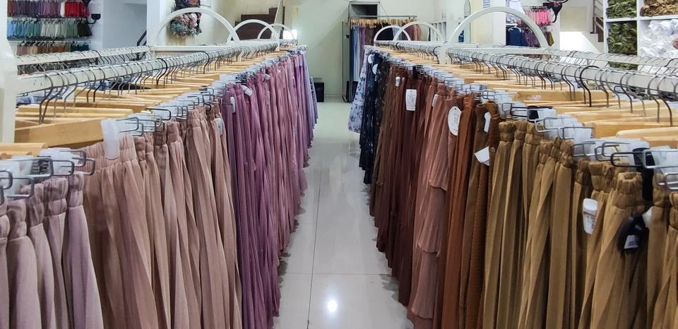Long skirts displayed on racks inside a clothing store Stock Photos