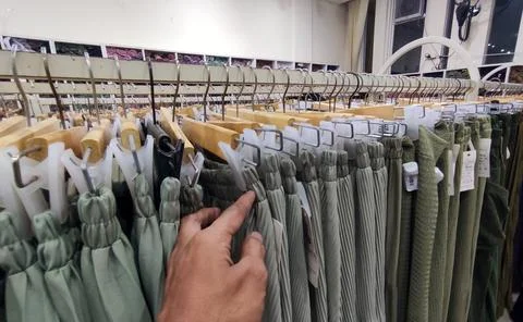 Long skirts displayed on racks inside a clothing store Stock Photos