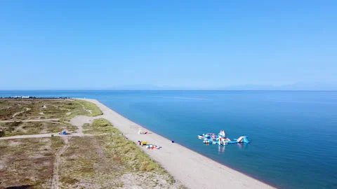 Long spacious beach with white sand and sea water park . Aerial view Stock Footage 135731871