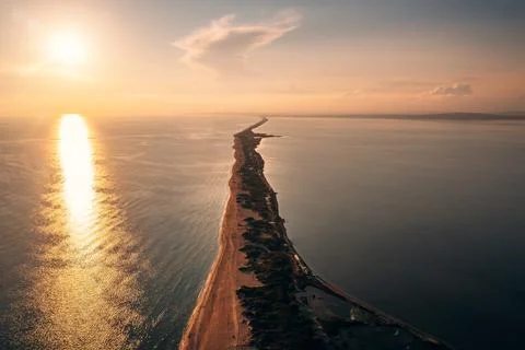 Long spit with sandy beach between sea and liman at sunset, aerial view from Stock Photos