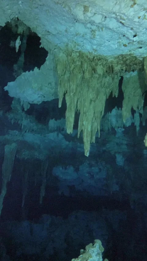 Long stalactites hanging above blue shadowed water Stock Footage 341361607
