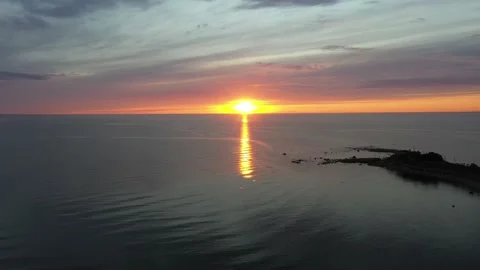 Long static aerial shot of a sunset over a house on the edge of a cliff Stock Footage 135227168