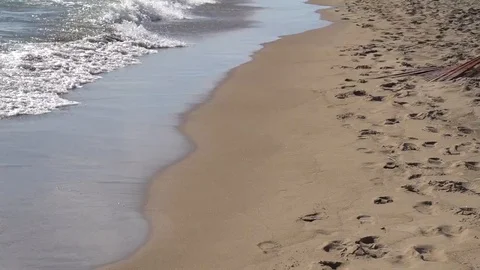 LONG STATIC SHOT OF WAVES CRASHING ON A LAKE BEACH WITH LOTS OF FOOTPRINTS Stock Footage 106131656